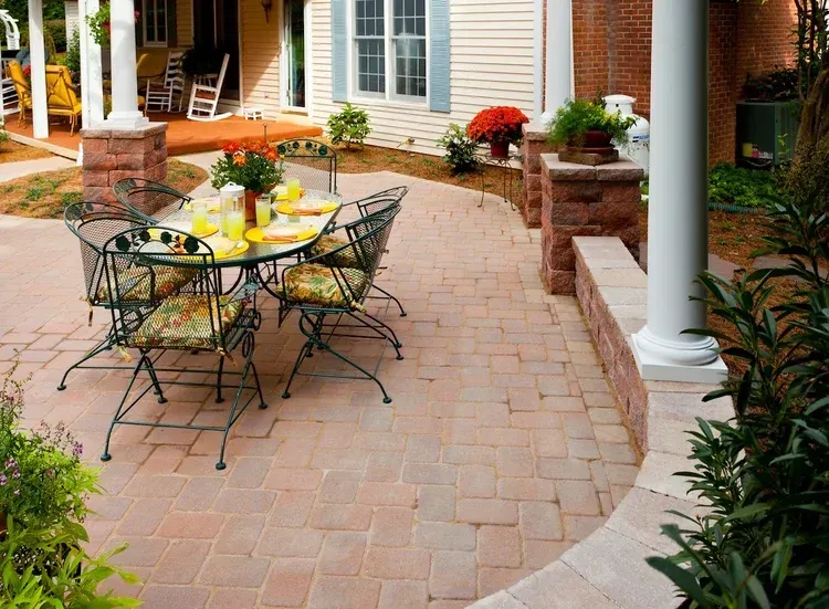 A patio with a table and chairs in front of a house