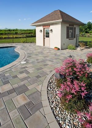 A small house is sitting next to a swimming pool