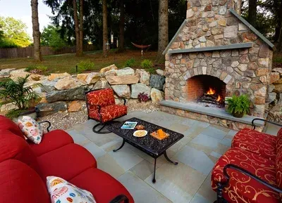 A patio with a fireplace and a couch and chairs