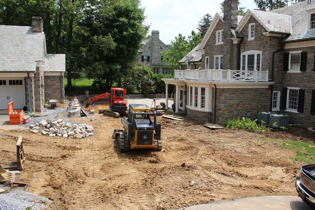 A construction site with a large house in the background