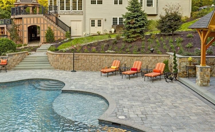 There is a large swimming pool in the backyard of a house.