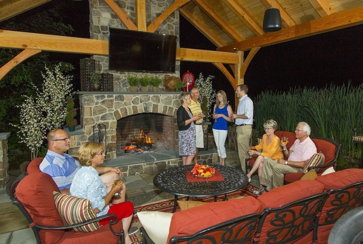 A group of people are sitting in front of a fireplace.