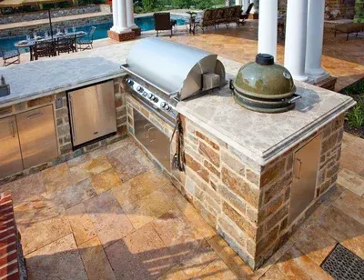 A large outdoor kitchen with a grill and a stainless steel dishwasher.