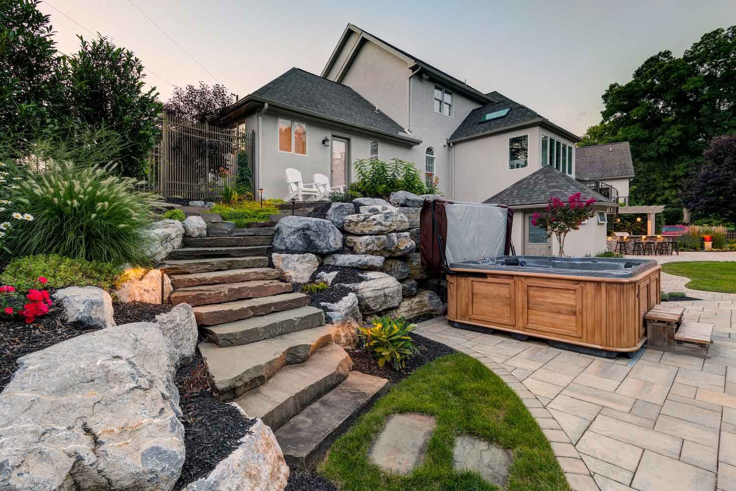 A patio with a table and chairs on it in front of a house.