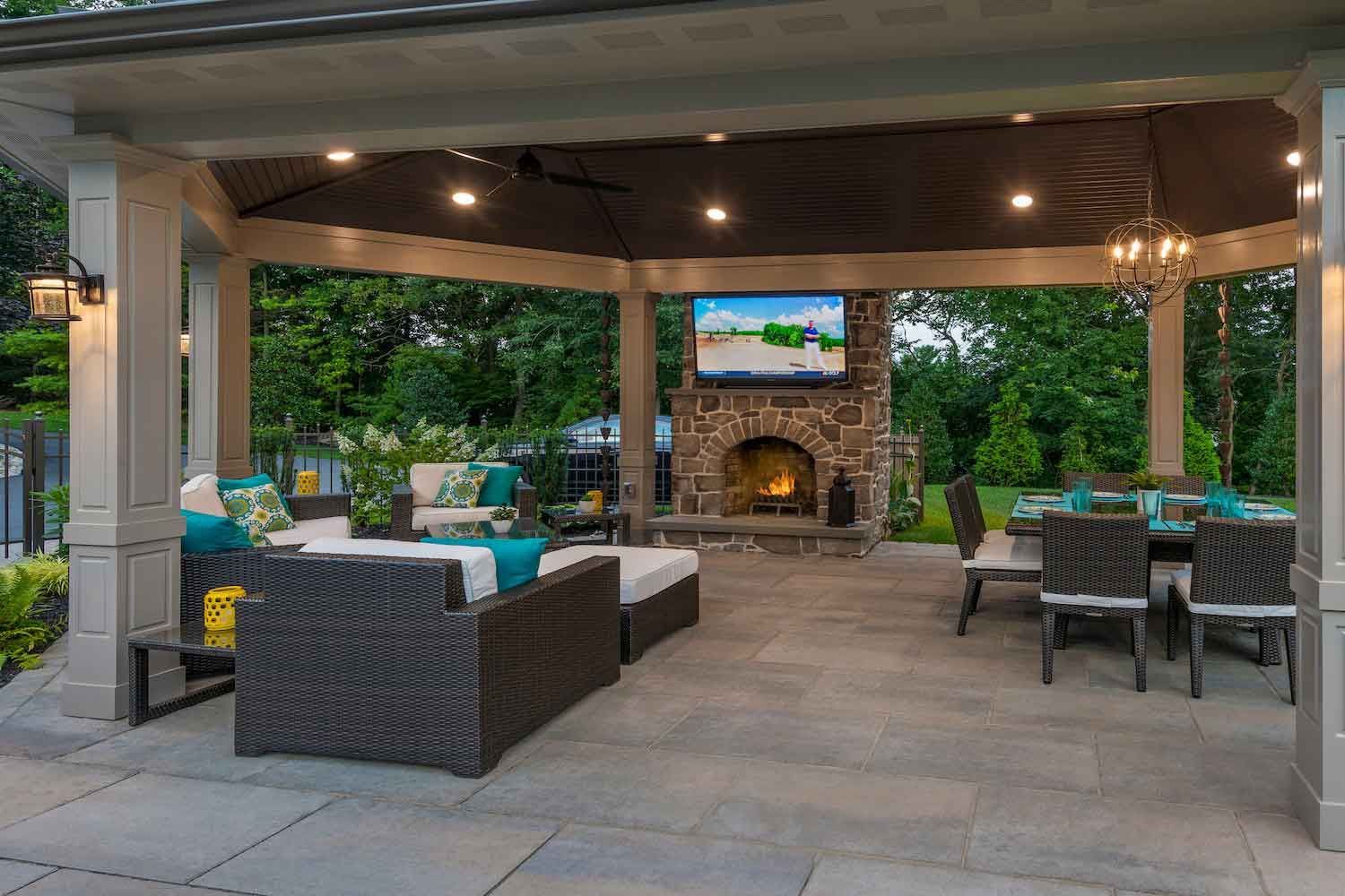 A patio with a table and chairs on it in front of a house.