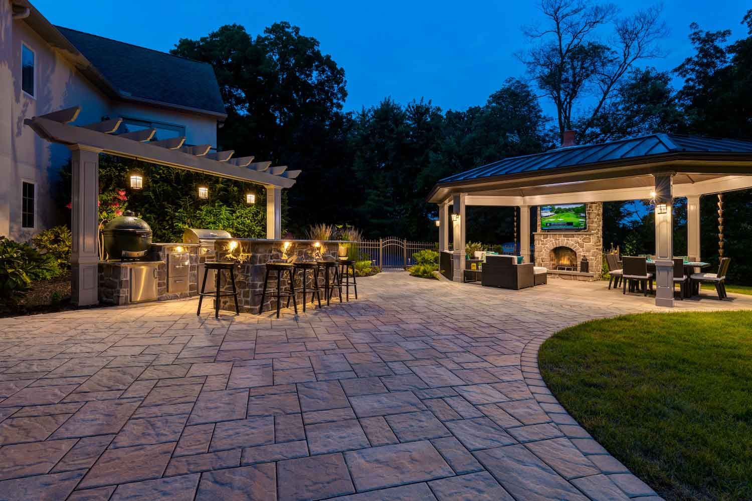 A patio with a table and chairs on it in front of a house.