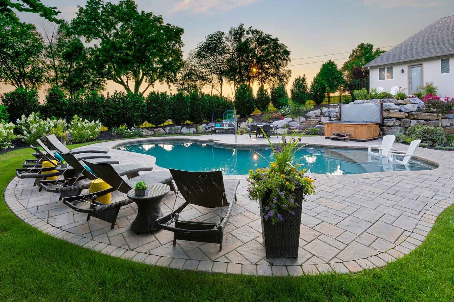 A patio with a table and chairs on it in front of a house.