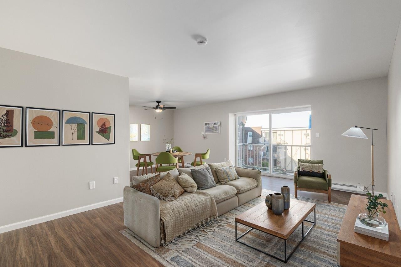 Living room in an apartment with a beige sofa, coffee table, and balcony door.