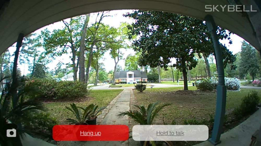 A security camera shows a house and trees in the background.