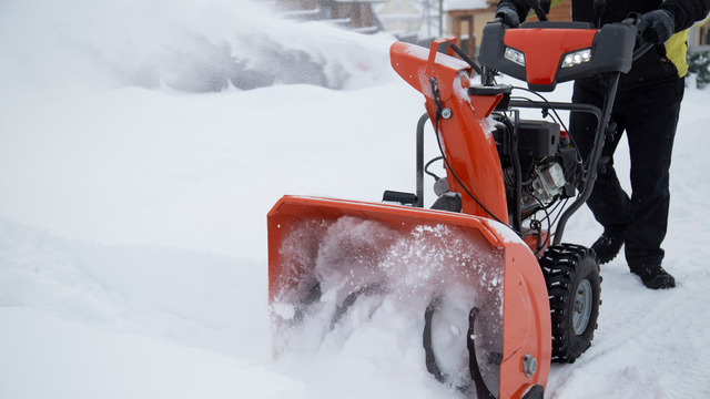 person pushing snow blower