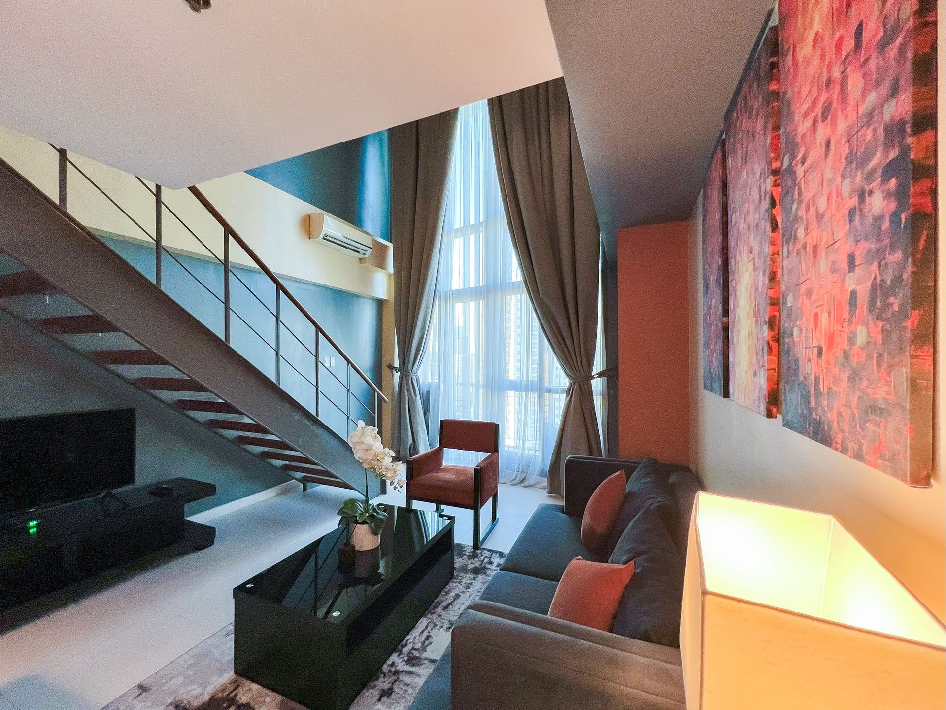 Spacious loft-style suite with stairs, living area and kitchenette, ideal for events or extended stays near shopping areas.