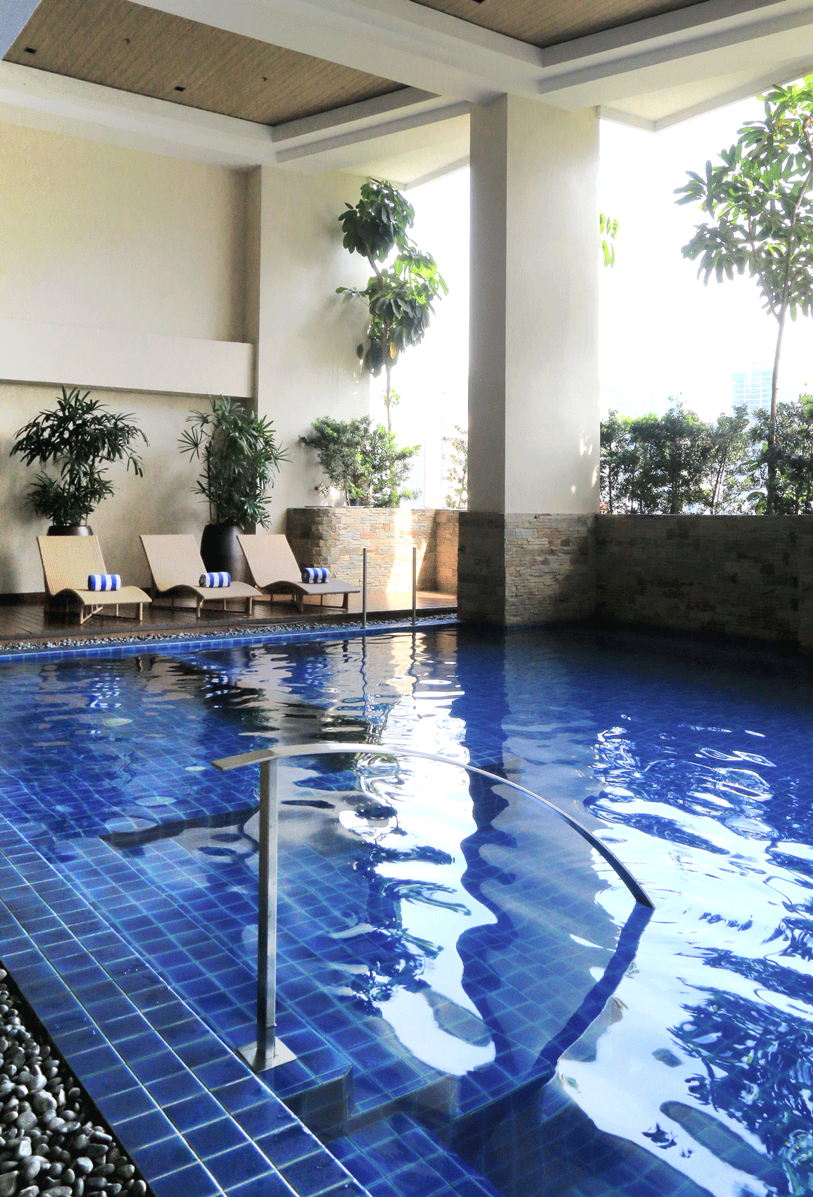 A large indoor swimming pool with blue tiles at a hotel near Greenbelt Makati