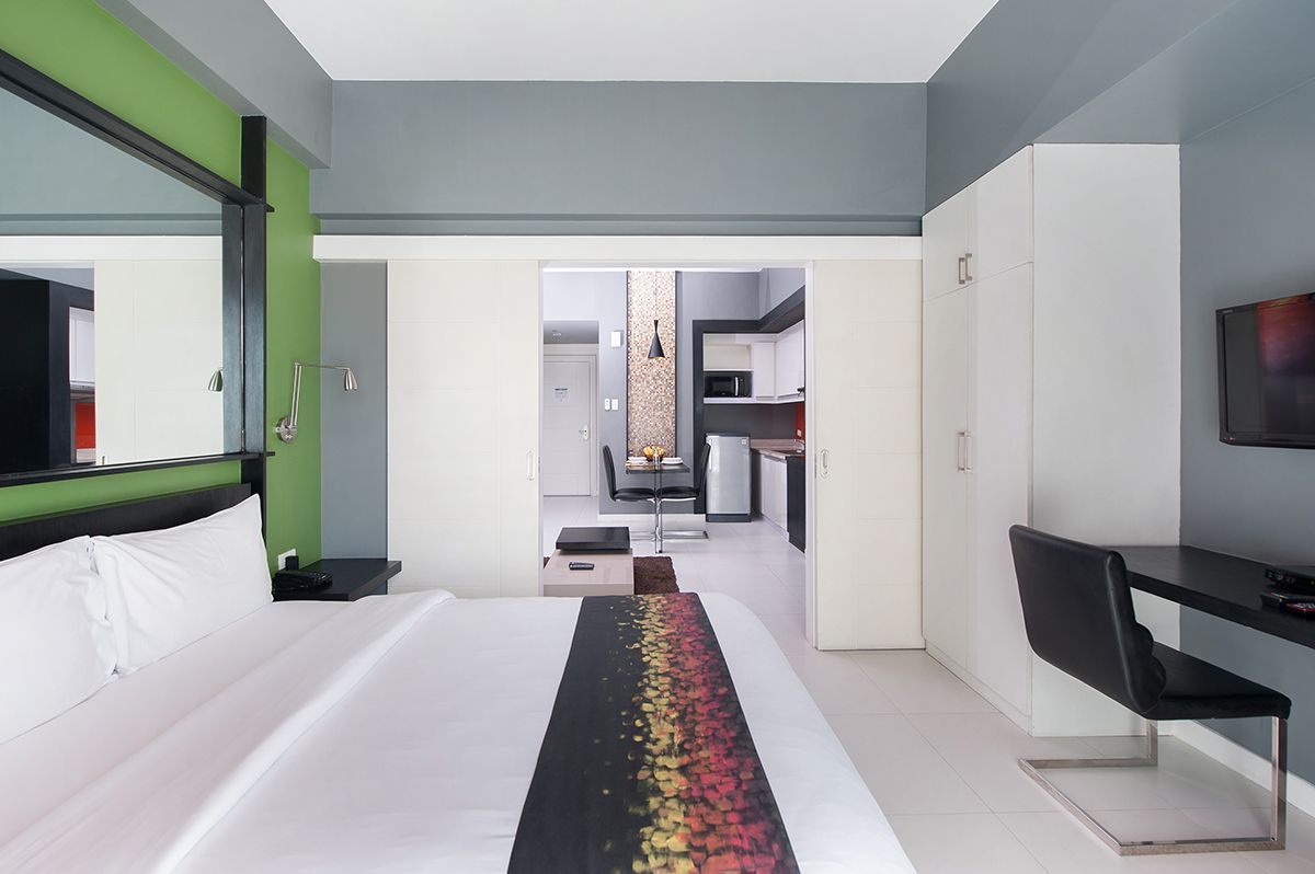 A modern hotel suite in KL Tower with a comfortable bed and dedicated work desk, providing premium accommodation for business travelers.