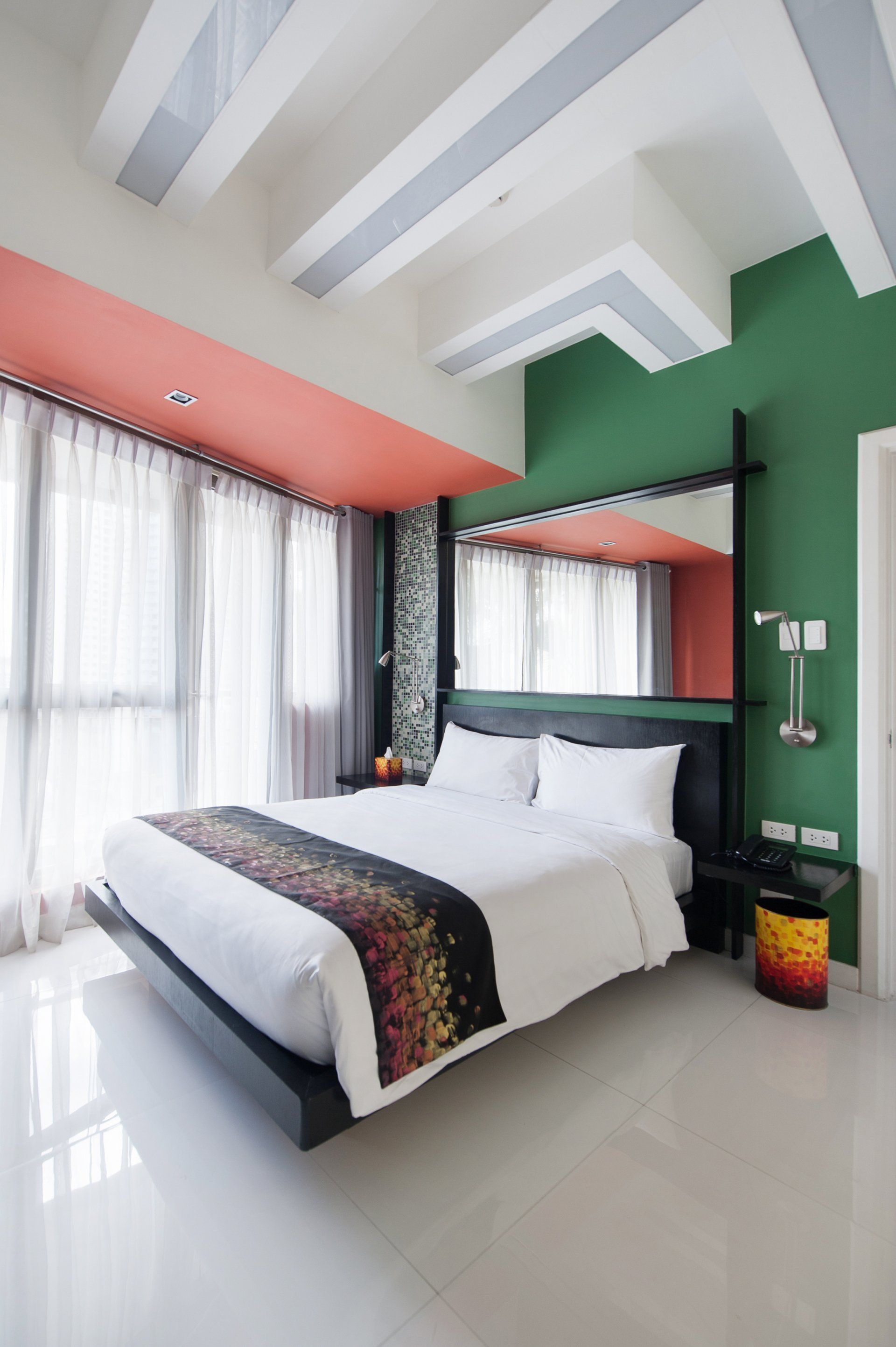 A king size bed and green walls for your staycation Makati with pool