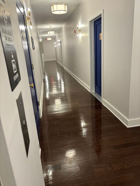 A long hallway with hardwood floors and blue doors.