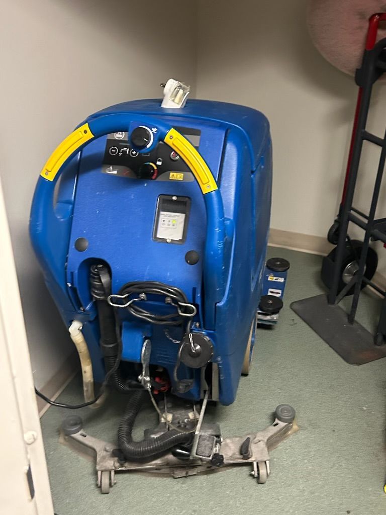 A blue machine is sitting on the floor in a room.