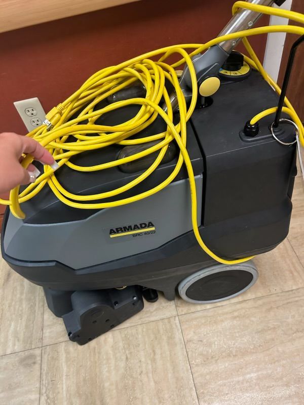 A vacuum cleaner with a yellow cord attached to it