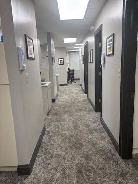 A long hallway with a carpeted floor in a dental office.