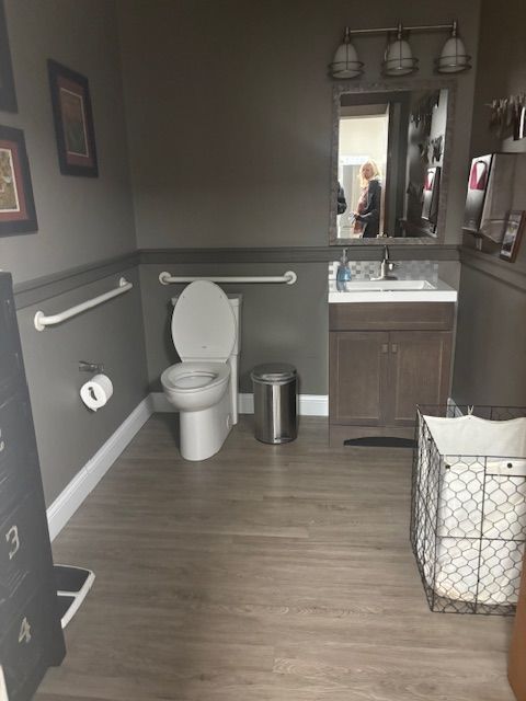 A bathroom with a toilet a sink and a mirror