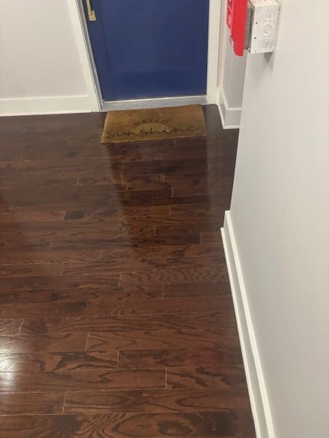 A hallway with hardwood floors and a blue door