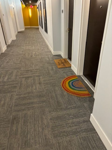 A hallway with a rainbow rug on the floor
