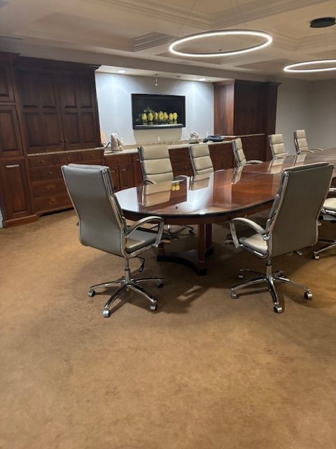 A conference room with a round table and chairs.