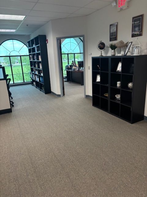 A room with a lot of shelves and a red exit sign