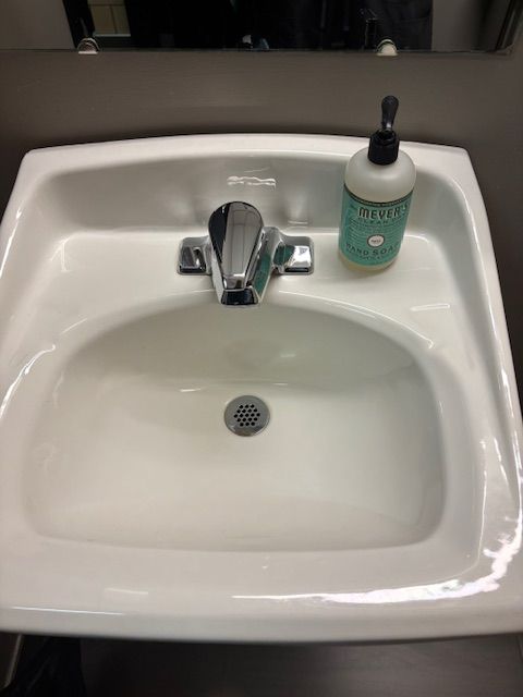 A bathroom sink with a bottle of hand soap on it