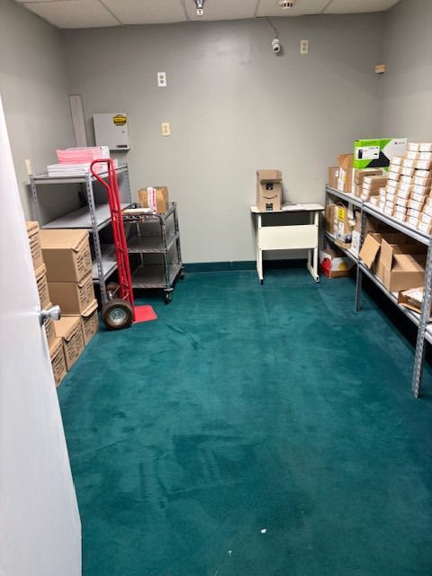 A room with a green carpet and boxes on shelves
