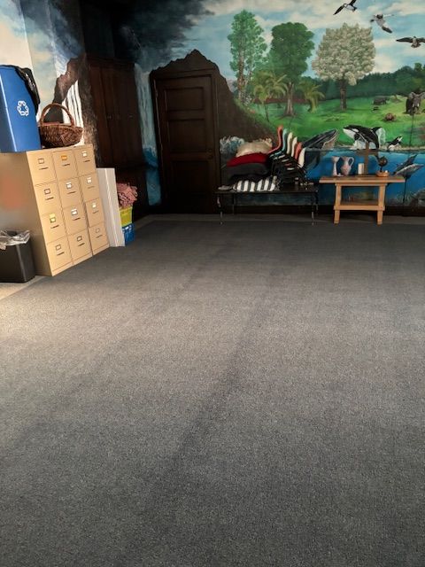 A room with a painting on the wall and a table