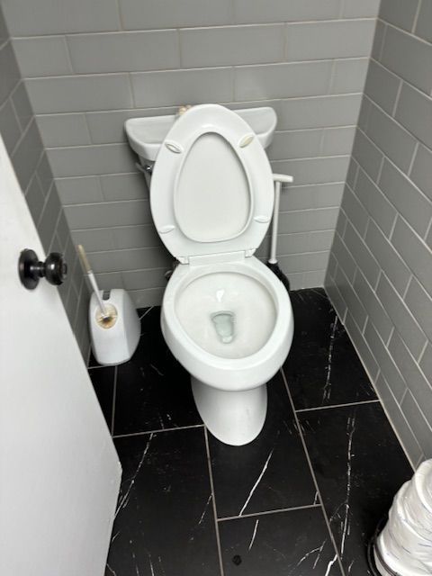 A toilet in a bathroom next to a door