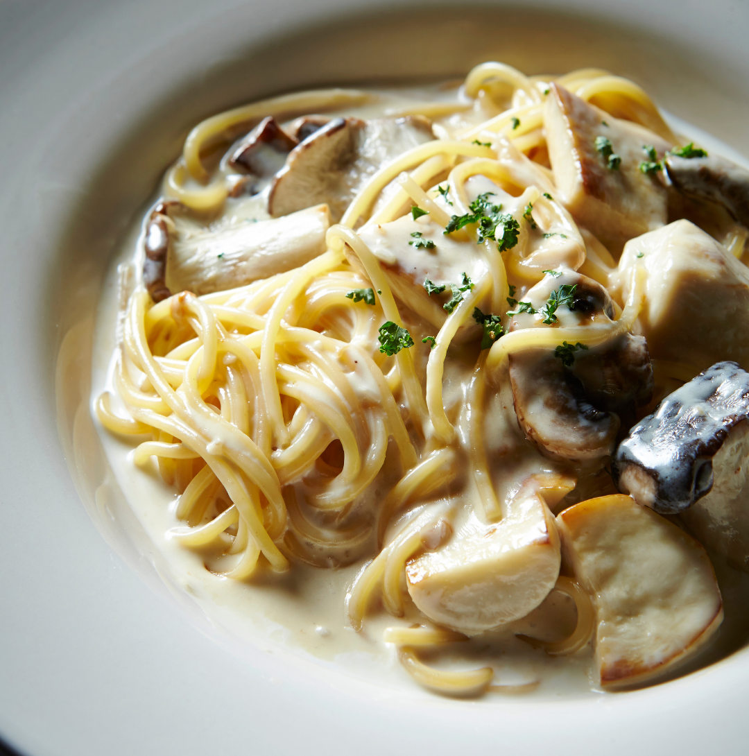 Une fourchette tenant un morceau de pâtes.