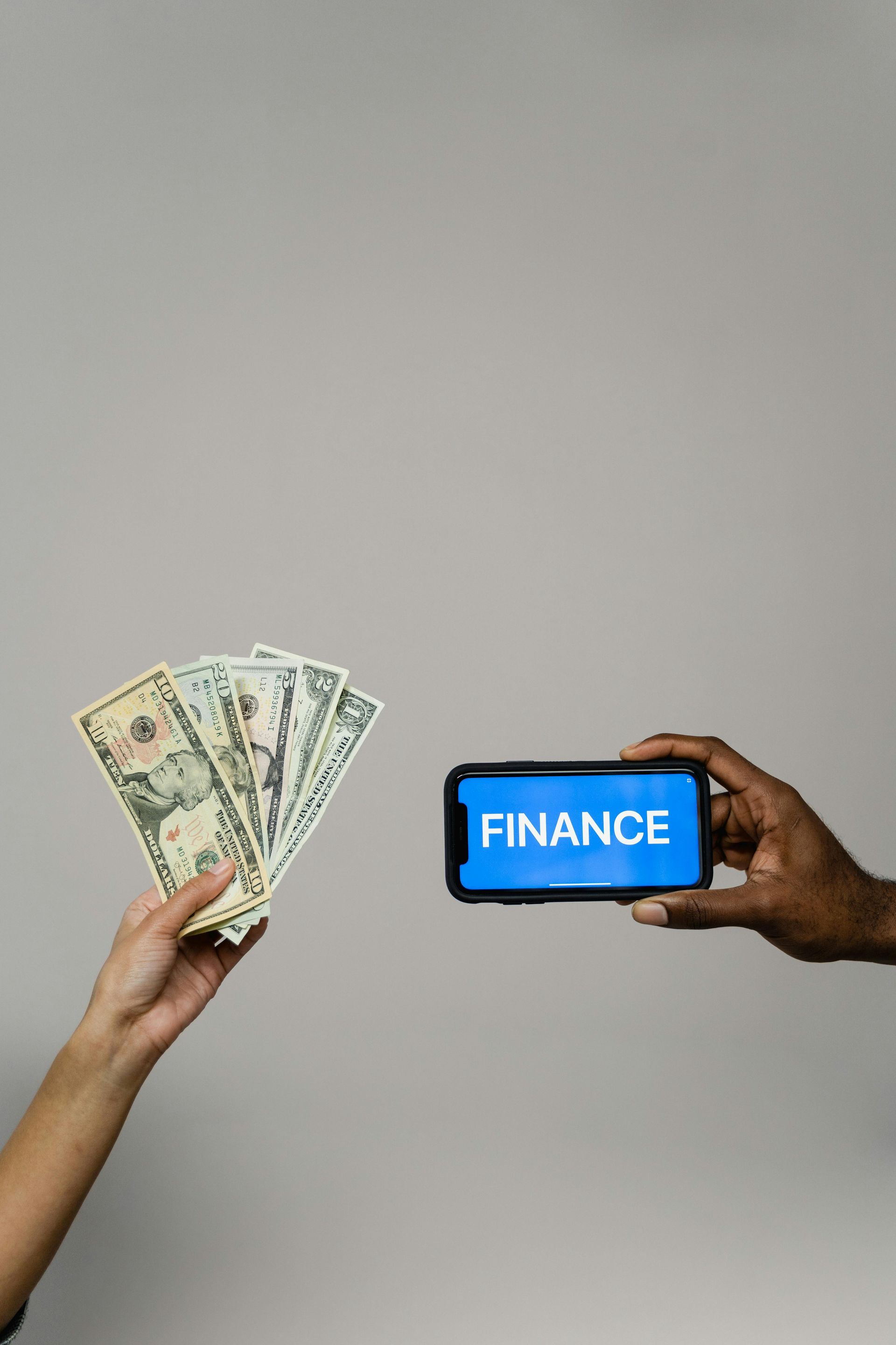 Hands holding cash and a smartphone with 