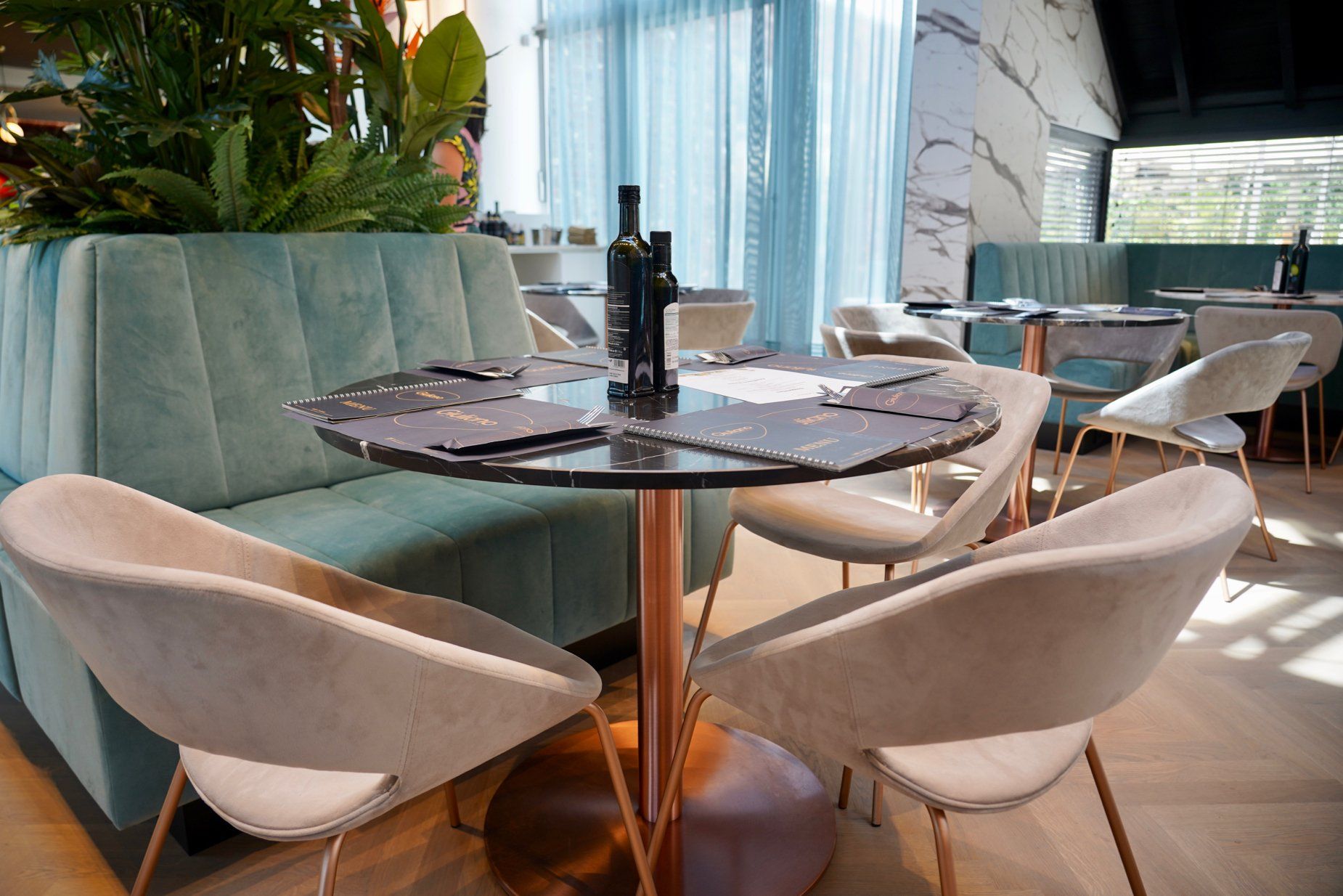 Plantenbak met zitbanken op maat. Gestoffeerde zetels. Stofferen maatwerk zitbanken. Schrijnwerkerij. Stoffeerderij. Maatwerk. Ontwerp interieurbouwers, interieurdesigners, interieurarchitecten. Voor horeca, retail, zorg en bedrijven.