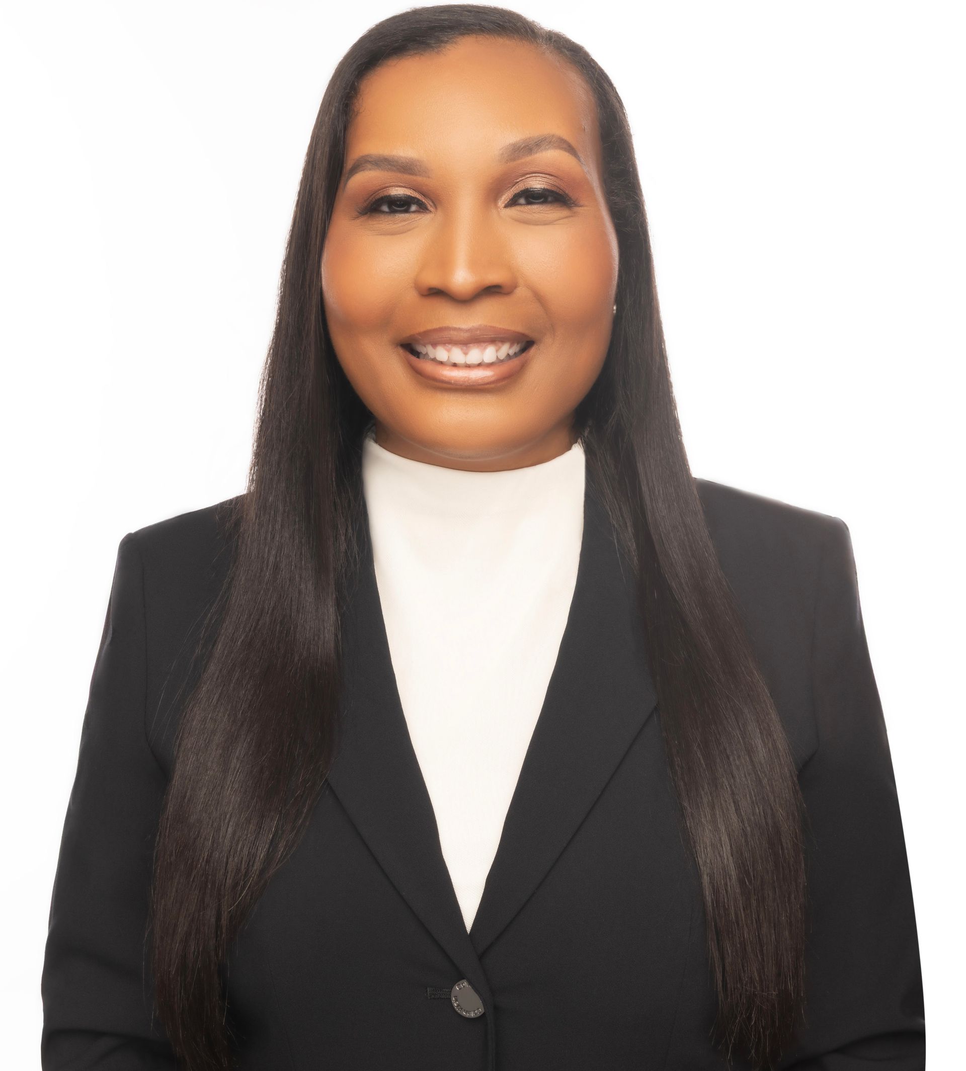 Woman in black blazer smiles, white turtleneck under, against white background.