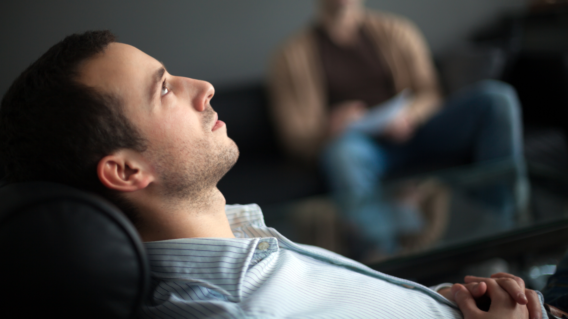 a man is laying in a chair with his eyes closed .