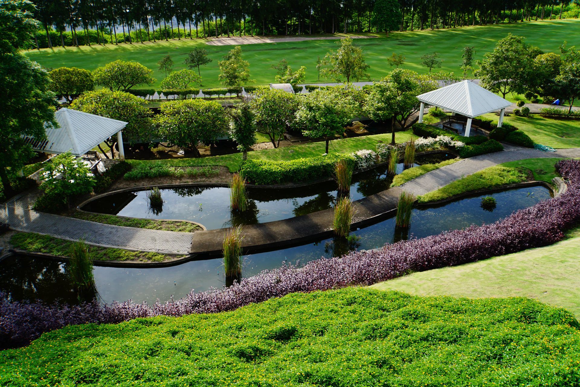 An aerial view of a park with a pond and a gazebo