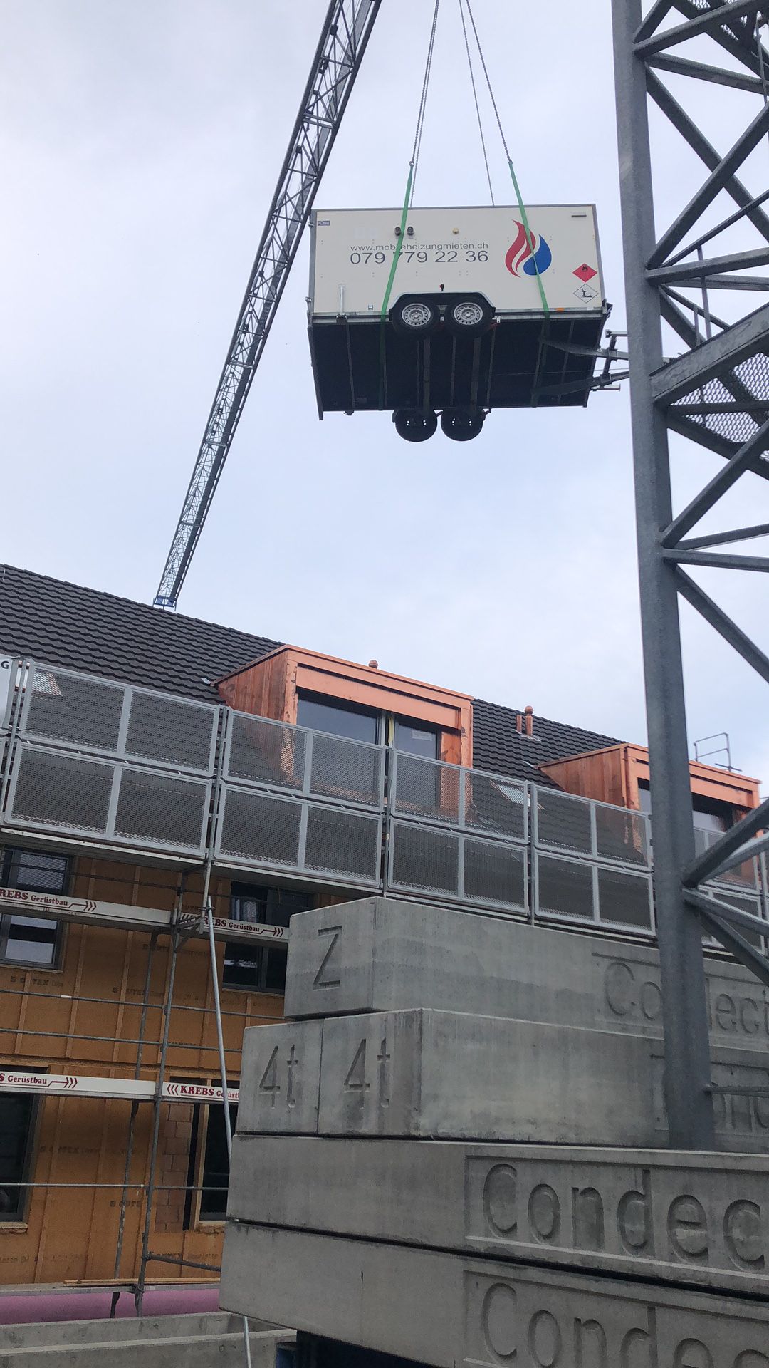 Ein großer Container wird von einem Kran angehoben.