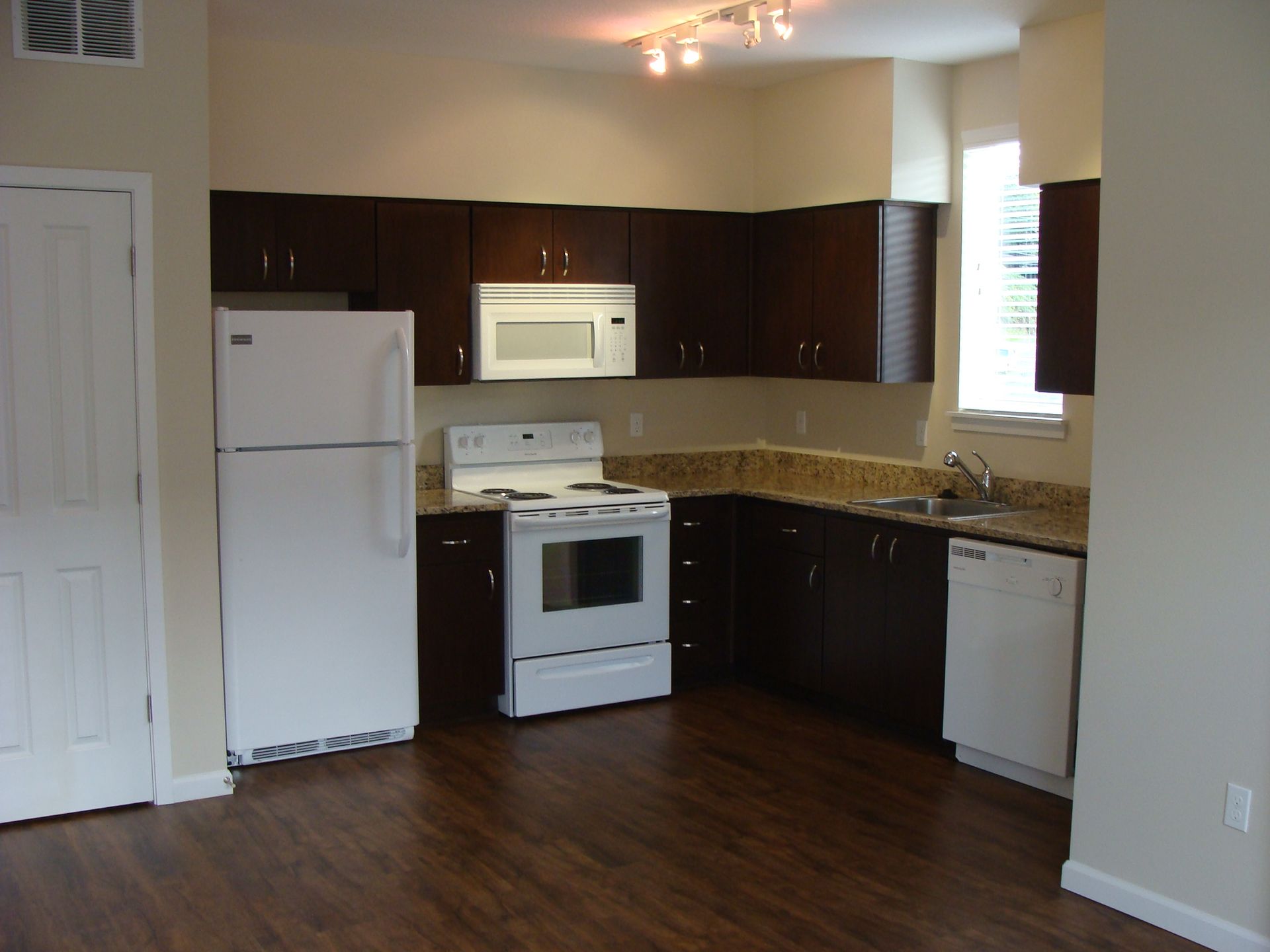 A kitchen with brown cabinets and a white refrigerator