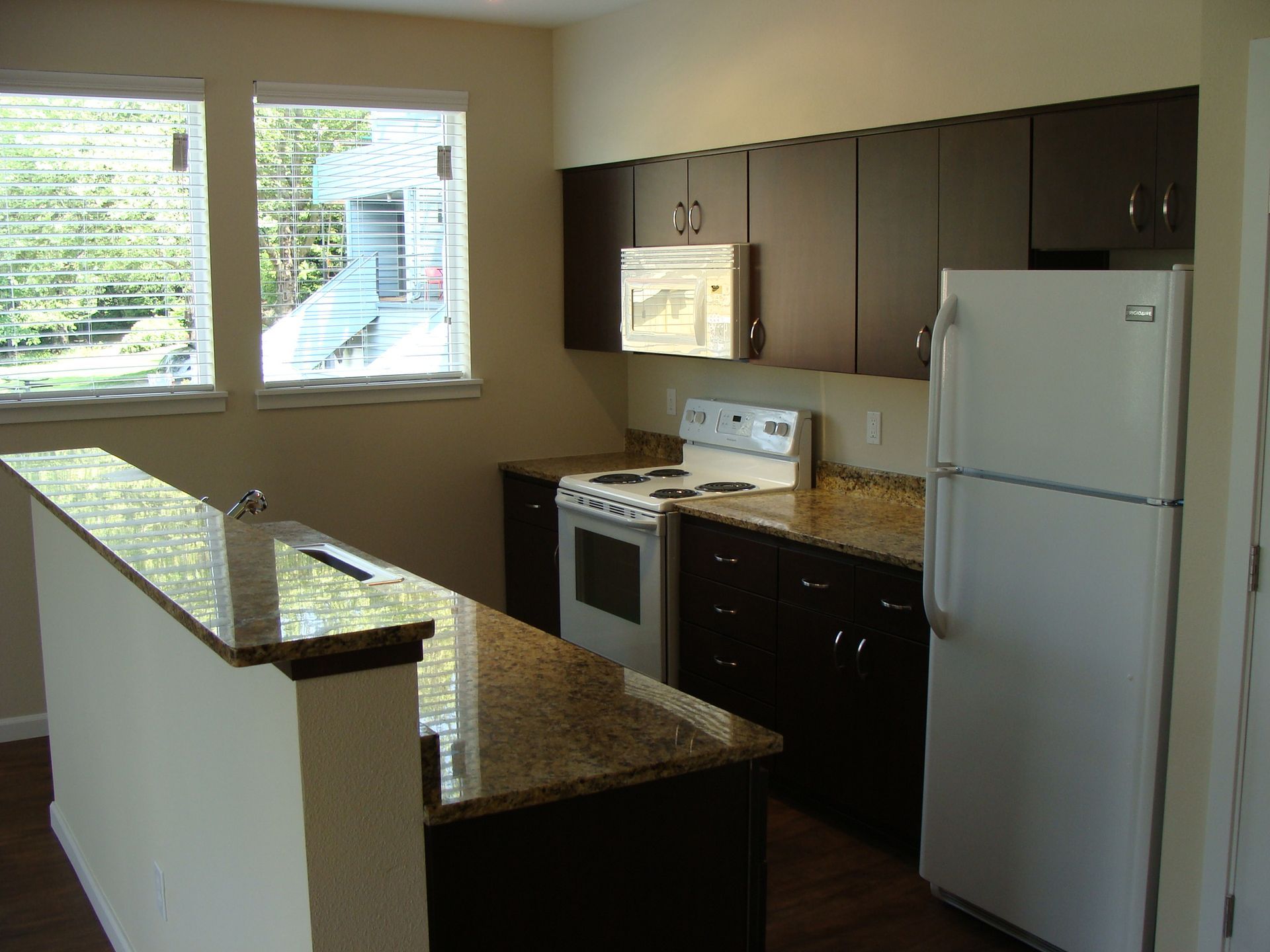 A kitchen with brown cabinets and a white refrigerator