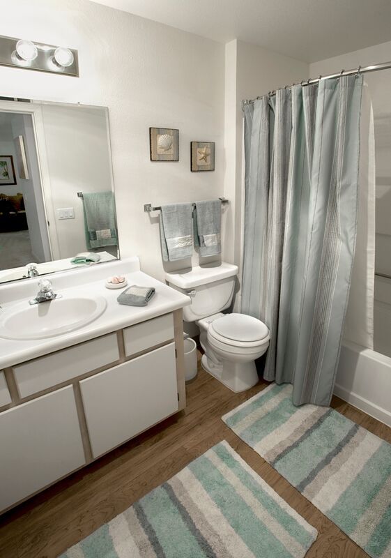 A bathroom with a toilet , sink , and shower curtain.