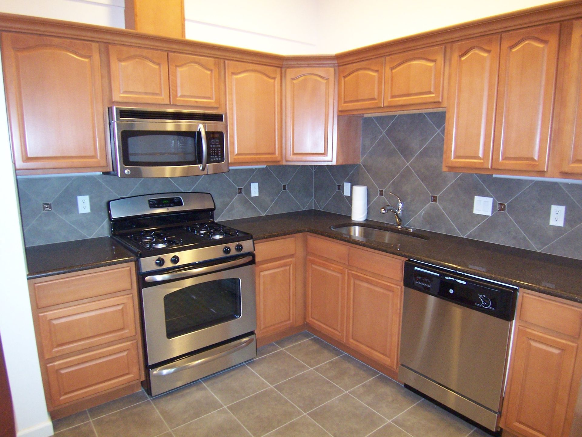 A kitchen with stainless steel appliances and wooden cabinets