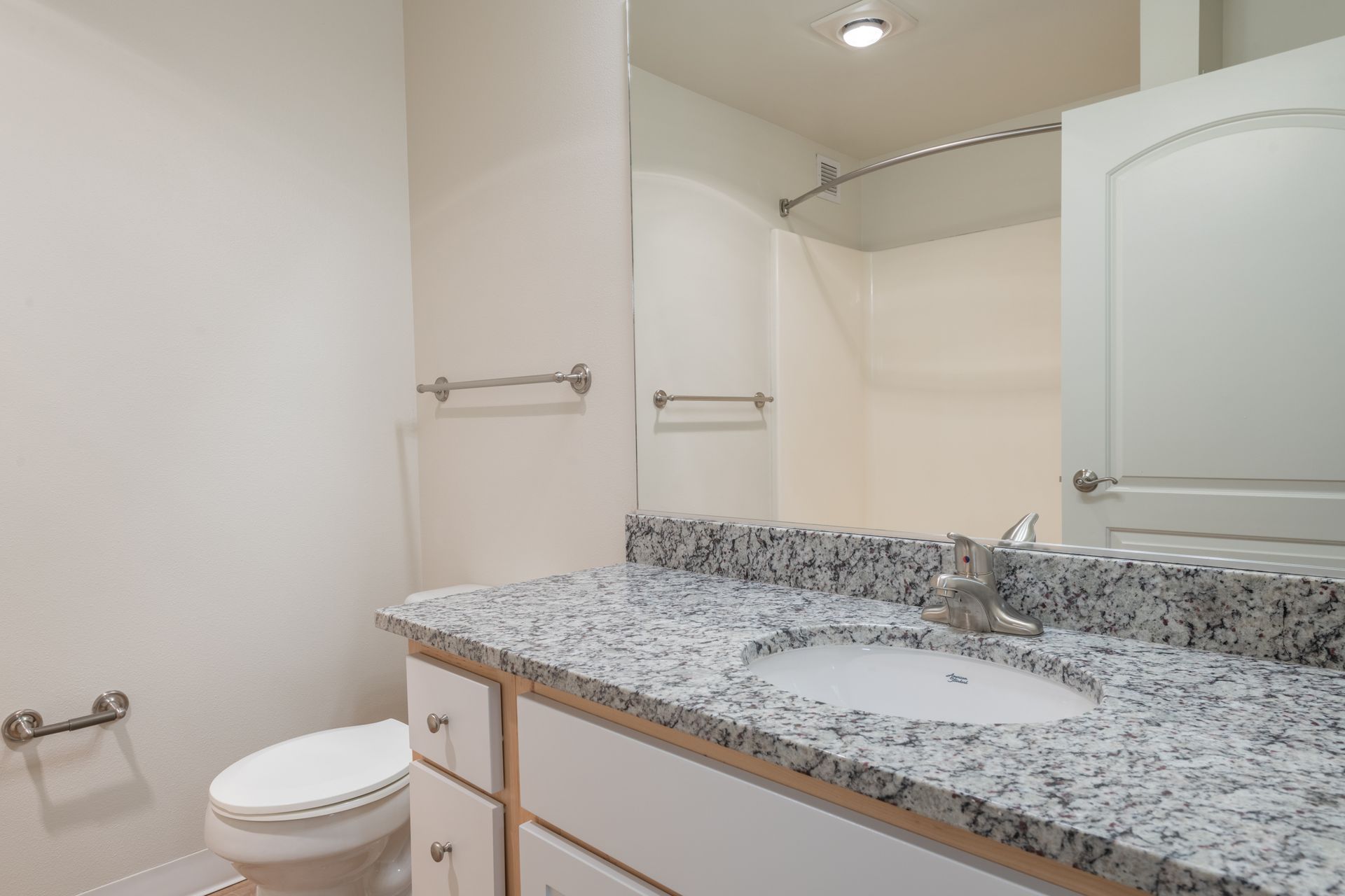 A bathroom with a sink , toilet , and mirror.