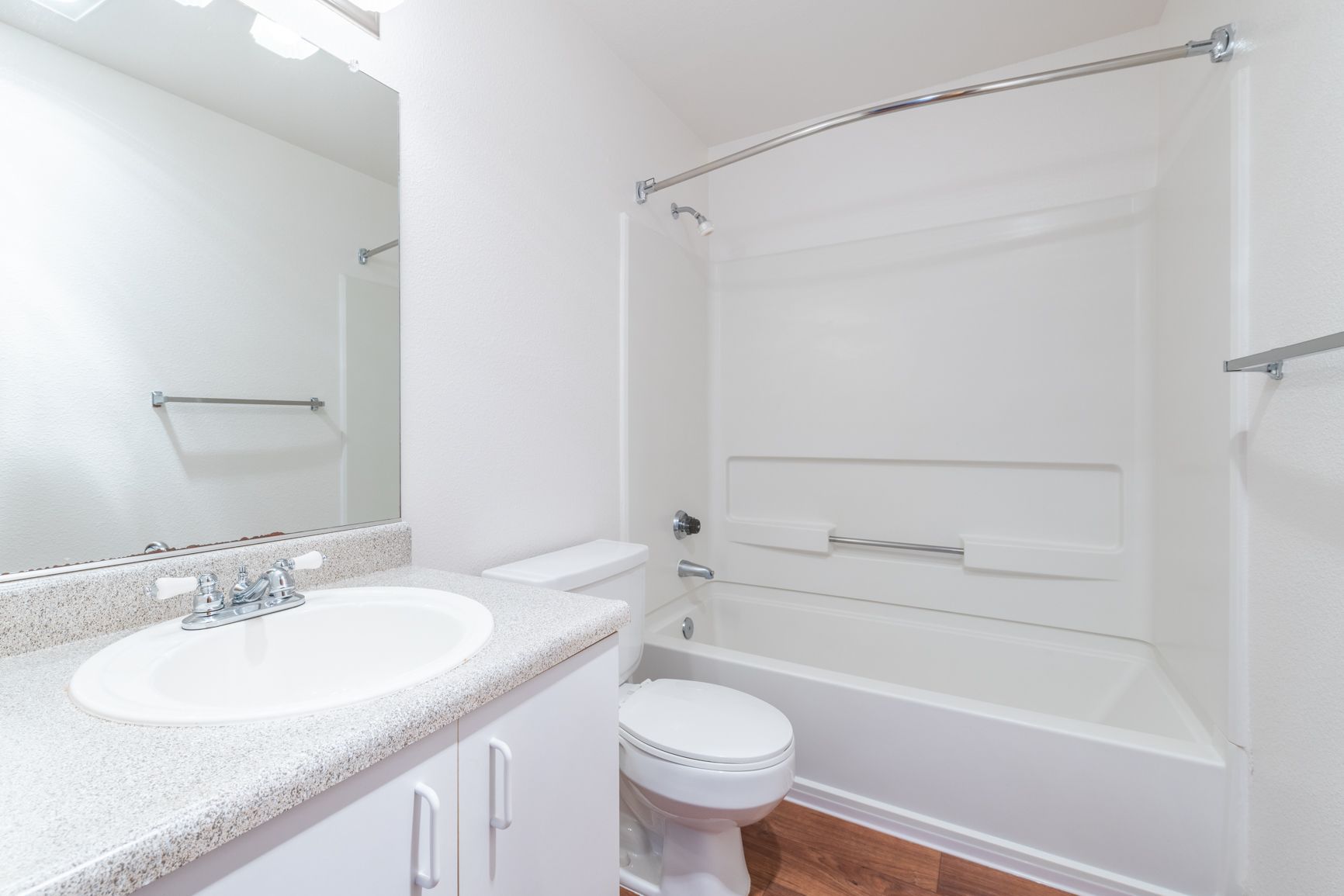 A bathroom with a sink , toilet , bathtub and mirror.