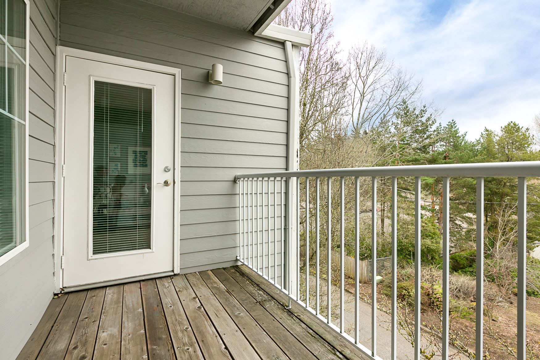 A balcony with a metal railing and a glass door.