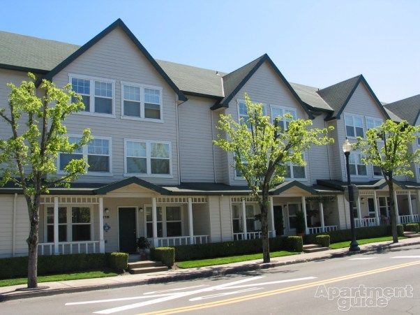 A row of apartment buildings with trees in front of them