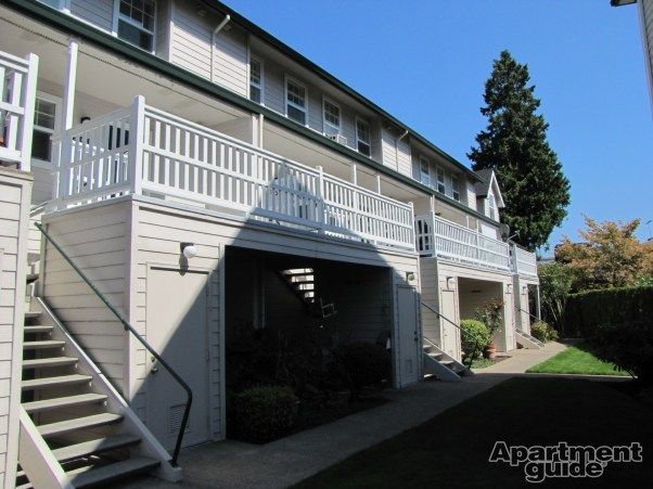 A white apartment building with stairs leading up to the second floor