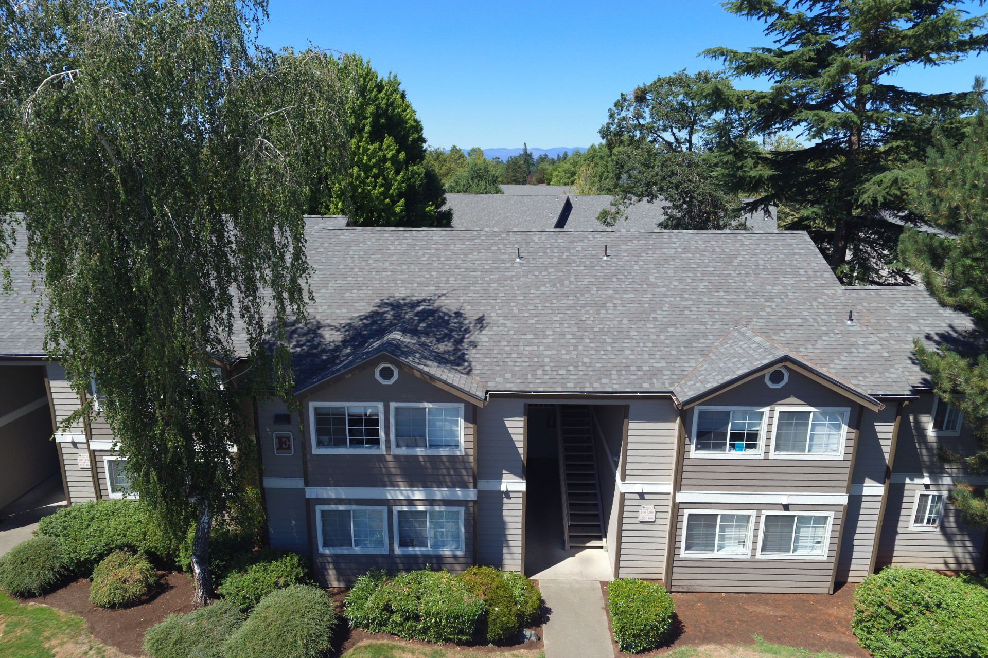 An aerial view of a house with a gray roof