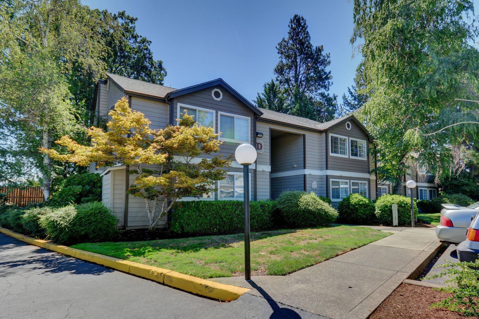 A large apartment building with a lot of windows and trees in the background
