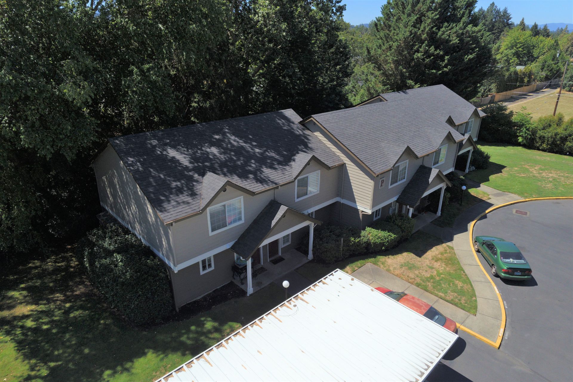 An aerial view of a house with a car parked in front of it